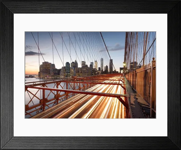 Framed Print : The view of the Financial District in New York City behind traffic on the Brooklyn Bridge after sunset Framed Print : The view of the Financial District in New York City behind traffic on the Brooklyn Bridge after sunset