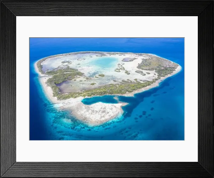 Framed Print : A remote tropical island in the Molucca Sea is fringed by mangrove forest surrounding a shallow lagoon. This island sits amid the Coral Triangle
