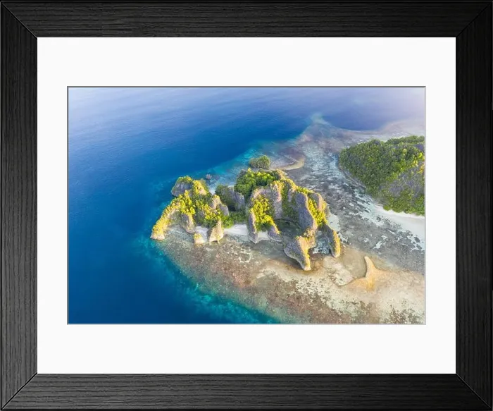 Framed Print : Seen from an aerial view, the tropical Pacific Ocean surrounds the rugged limestone islands scattered throughout the amazing seascape of Raja Ampat Framed Print : Seen from an aerial view, the tropical Pacific Ocean surrounds the rugged limestone islands scattered throughout the amazing seascape of Raja Ampat