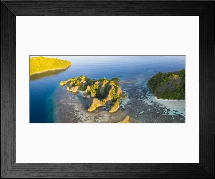 Framed Print : Seen from an aerial view, the tropical Pacific Ocean surrounds the rugged limestone islands scattered throughout the amazing seascape of Raja Ampat Framed Print : Seen from an aerial view, the tropical Pacific Ocean surrounds the rugged limestone islands scattered throughout the amazing seascape of Raja Ampat