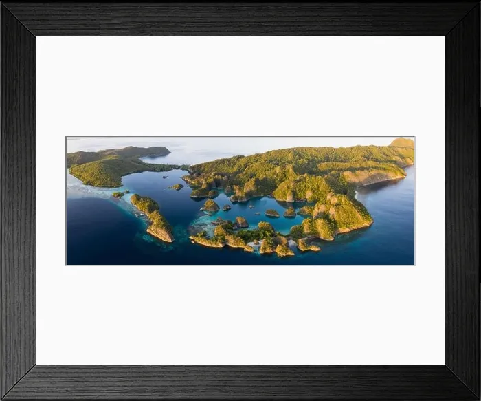 Framed Print : Seen from an aerial view, the tropical Pacific Ocean surrounds the rugged limestone islands scattered throughout the amazing seascape of Raja Ampat Framed Print : Seen from an aerial view, the tropical Pacific Ocean surrounds the rugged limestone islands scattered throughout the amazing seascape of Raja Ampat