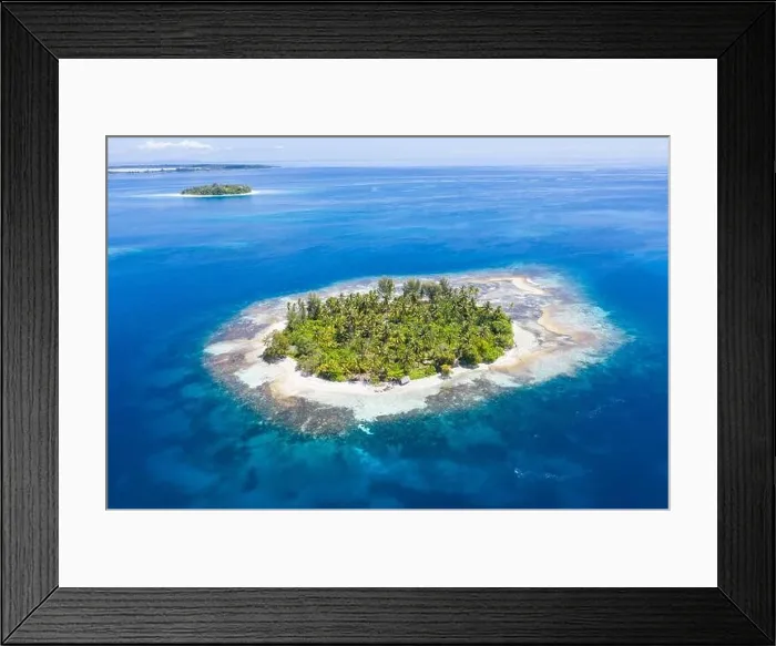 Framed Print : A remote, tropical island in the Molucca Sea, Indonesia, is surrounded by a healthy coral reef. This region is home to incredible marine biodiversity Framed Print : A remote, tropical island in the Molucca Sea, Indonesia, is surrounded by a healthy coral reef. This region is home to incredible marine biodiversity