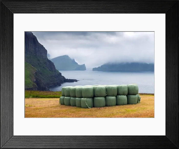 Framed Print : Rural scene with farm field and hay stacks on the Gasadalur village, Vagar island, Faroe Islands. Drangarnir and Tindholmur on background Framed Print : Rural scene with farm field and hay stacks on the Gasadalur village, Vagar island, Faroe Islands. Drangarnir and Tindholmur on background