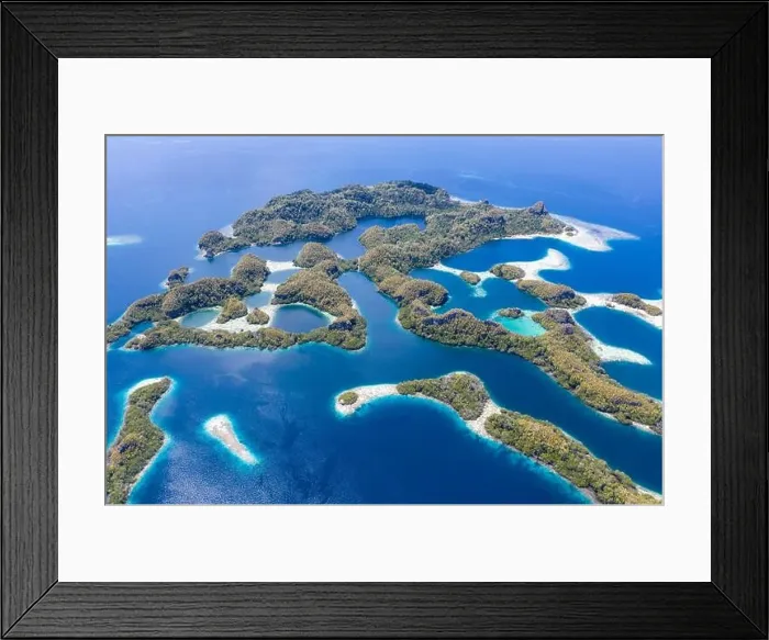 Framed Print : Forest-covered limestone islands rise from the seascape in Raja Ampat, Indonesia. This remote region is known for its great marine biodiversity Framed Print : Forest-covered limestone islands rise from the seascape in Raja Ampat, Indonesia. This remote region is known for its great marine biodiversity