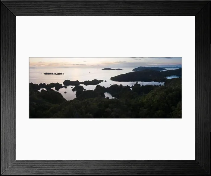 Framed Print : A tranquil sunrise greets the limestone islands in Raja Ampat, Indonesia. This region is thought to be the world's epicenter of marine biodiversity Framed Print : A tranquil sunrise greets the limestone islands in Raja Ampat, Indonesia. This region is thought to be the world's epicenter of marine biodiversity