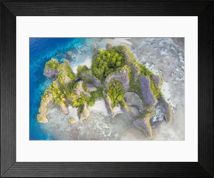 Framed Print : Rugged limestone islands rise from the serene seascape in Raja Ampat, Indonesia. This tropical region is known as the heart of the Coral Triangle Framed Print : Rugged limestone islands rise from the serene seascape in Raja Ampat, Indonesia. This tropical region is known as the heart of the Coral Triangle