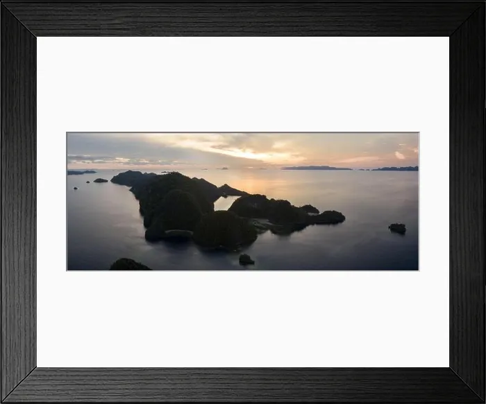 Framed Print : A serene sunrise illuminates the dramatic limestone islands within Raja Ampat, Indonesia. This region is the world's epicenter of marine biodiversity Framed Print : A serene sunrise illuminates the dramatic limestone islands within Raja Ampat, Indonesia. This region is the world's epicenter of marine biodiversity