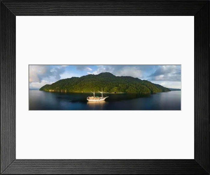 Framed Print : A tranquil sunrise illuminates a Phinisi schooner on the Pacific Ocean not far from Fak Fak, West Papua, Indonesia Framed Print : A tranquil sunrise illuminates a Phinisi schooner on the Pacific Ocean not far from Fak Fak, West Papua, Indonesia