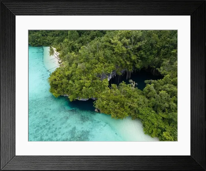 Framed Print : The mouth of a dark, water-filled cave opens on the edge of a forest-covered limestone island near Fak Fak, Indonesia. Limestone often harbors caves Framed Print : The mouth of a dark, water-filled cave opens on the edge of a forest-covered limestone island near Fak Fak, Indonesia. Limestone often harbors caves