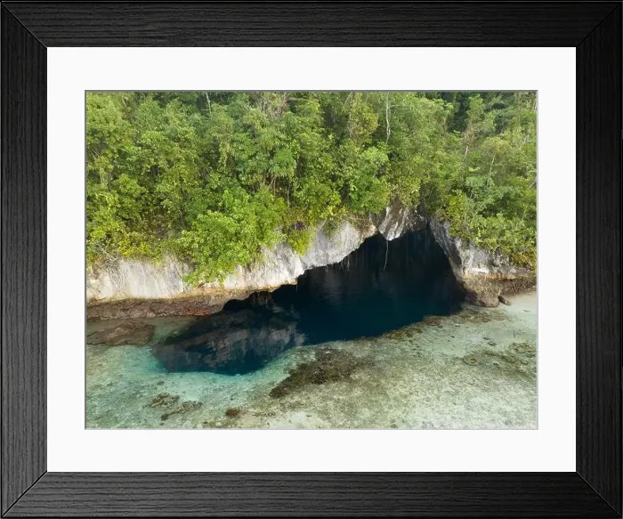 Framed Print : The mouth of a dark, water-filled cave opens on the edge of a forest-covered limestone island near Fak Fak, Indonesia. Limestone often harbors caves Framed Print : The mouth of a dark, water-filled cave opens on the edge of a forest-covered limestone island near Fak Fak, Indonesia. Limestone often harbors caves