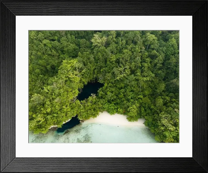 Framed Print : The mouth of a dark, water-filled cave opens on the edge of a forest-covered limestone island near Fak Fak, Indonesia. Limestone often harbors caves Framed Print : The mouth of a dark, water-filled cave opens on the edge of a forest-covered limestone island near Fak Fak, Indonesia. Limestone often harbors caves