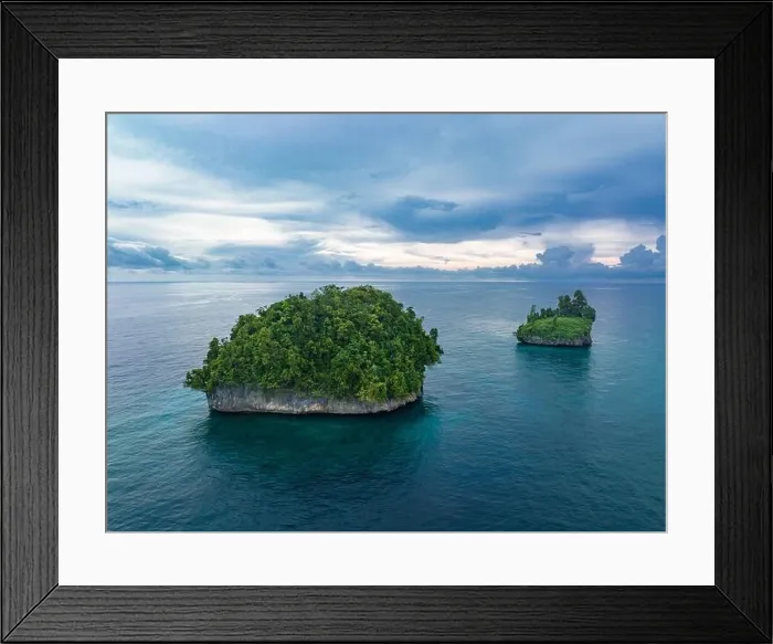 Framed Print : A pair of limestone islands, covered by vegetation, rise from West Papua's seascape. This region of Indonesia is known for its high biodiversity Framed Print : A pair of limestone islands, covered by vegetation, rise from West Papua's seascape. This region of Indonesia is known for its high biodiversity