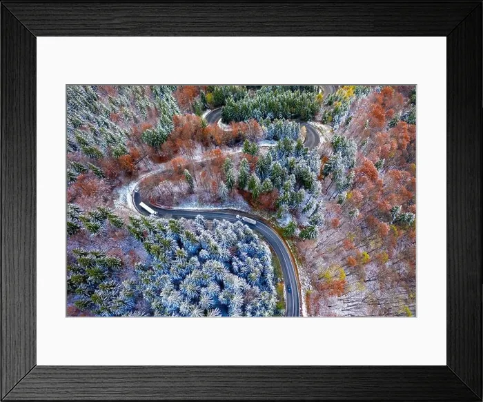 Framed Print : Aerial view of a winding mountain road passing through a fir trees forest. Winter with snow Framed Print : Aerial view of a winding mountain road passing through a fir trees forest. Winter with snow