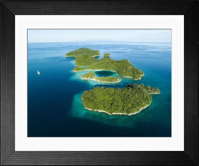 Framed Print : Coral reefs surround the rugged limestone islands that rise from West Papua's seascape. This remote part of Indonesia has high marine biodiversity Framed Print : Coral reefs surround the rugged limestone islands that rise from West Papua's seascape. This remote part of Indonesia has high marine biodiversity