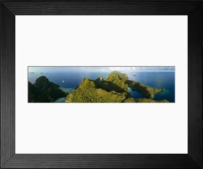 Framed Print : Coral reefs surround the rugged limestone islands that rise from Raja Ampat's seascape. This remote part of Indonesia has high marine biodiversity