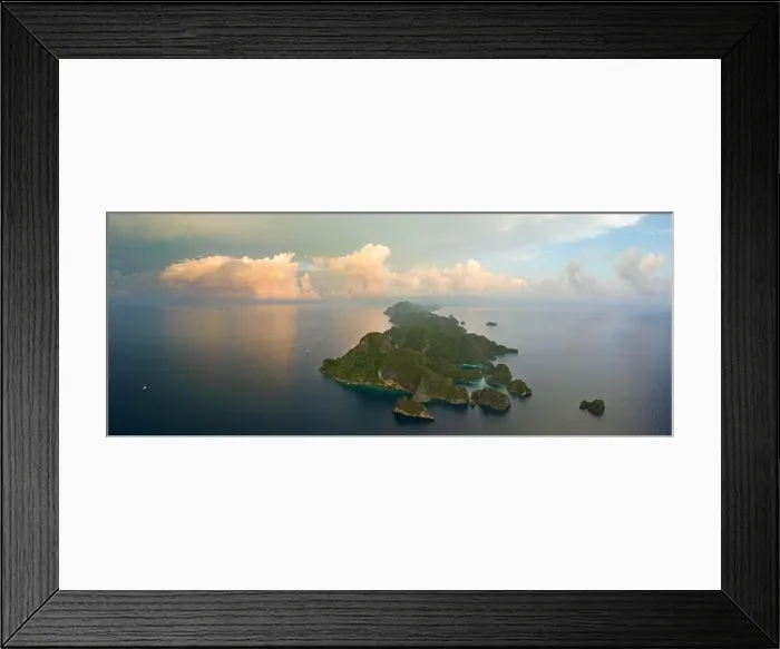 Framed Print : Sunrise illuminates dramatic limestone islands that rise from Raja Ampat's beautiful seascape. This area is known for its high marine biodiversity