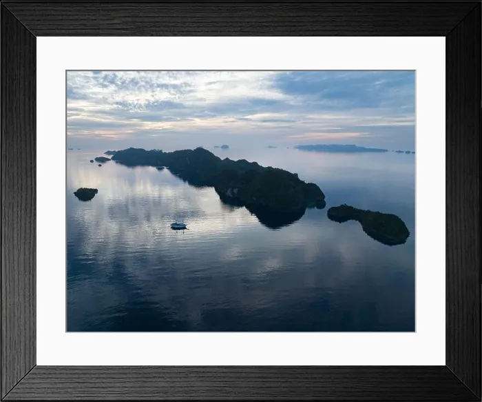 Framed Print : A peaceful sunrise illuminates dramatic limestone islands that rise from Raja Ampat's beautiful seascape. This area has high marine biodiversity Framed Print : A peaceful sunrise illuminates dramatic limestone islands that rise from Raja Ampat's beautiful seascape. This area has high marine biodiversity