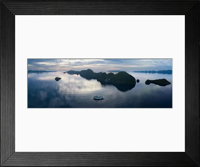 Framed Print : A peaceful sunrise illuminates dramatic limestone islands that rise from Raja Ampat's beautiful seascape. This area has high marine biodiversity Framed Print : A peaceful sunrise illuminates dramatic limestone islands that rise from Raja Ampat's beautiful seascape. This area has high marine biodiversity