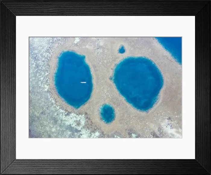 Framed Print : Blue holes are found amid a shallow reef flat on the island of Sebayor in Komodo National Park, Indonesia. These blue holes formed as sink holes Framed Print : Blue holes are found amid a shallow reef flat on the island of Sebayor in Komodo National Park, Indonesia. These blue holes formed as sink holes