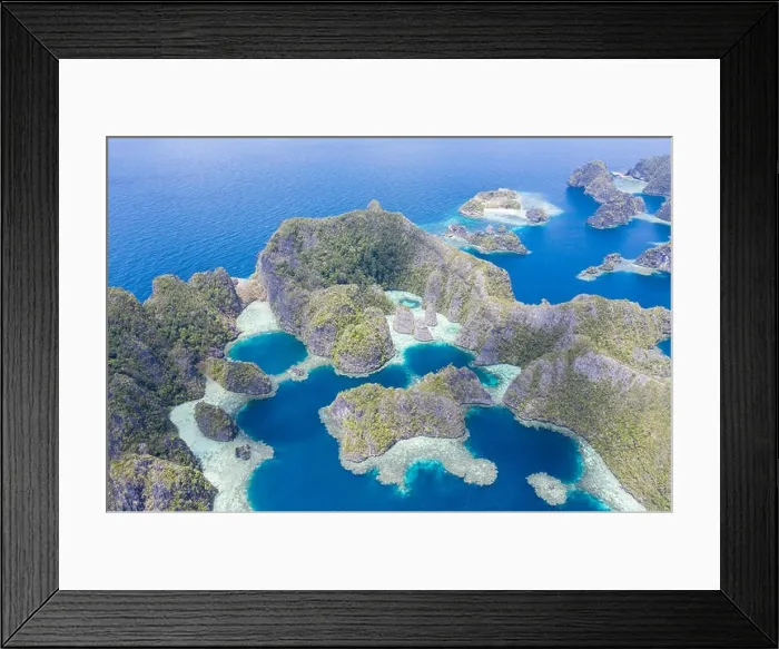Framed Print : Highly eroded limestone islands rise from the beautiful, tropical seascape in Raja Ampat, Indonesia. This remote region is known for its biodiversity Framed Print : Highly eroded limestone islands rise from the beautiful, tropical seascape in Raja Ampat, Indonesia. This remote region is known for its biodiversity