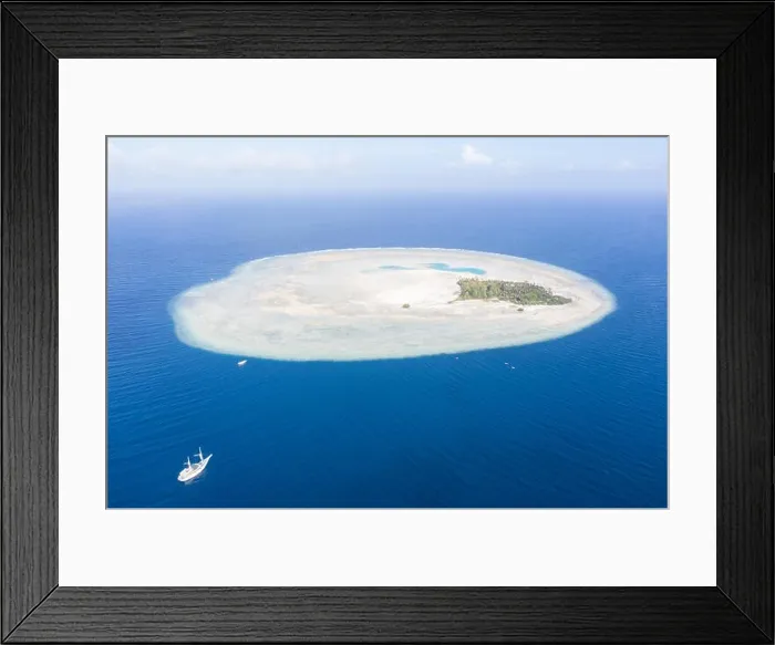 Framed Print : A Pinisi schooner drifts near the remote, tropical island of Midorang in the Ceram Sea. This area harbors extremely high marine biodiversity Framed Print : A Pinisi schooner drifts near the remote, tropical island of Midorang in the Ceram Sea. This area harbors extremely high marine biodiversity