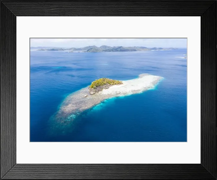 Framed Print : A beautiful coral reef surrounds a small island amid the tropical seascape in Raja Ampat, Indonesia. This remote region is known for its biodiversity Framed Print : A beautiful coral reef surrounds a small island amid the tropical seascape in Raja Ampat, Indonesia. This remote region is known for its biodiversity