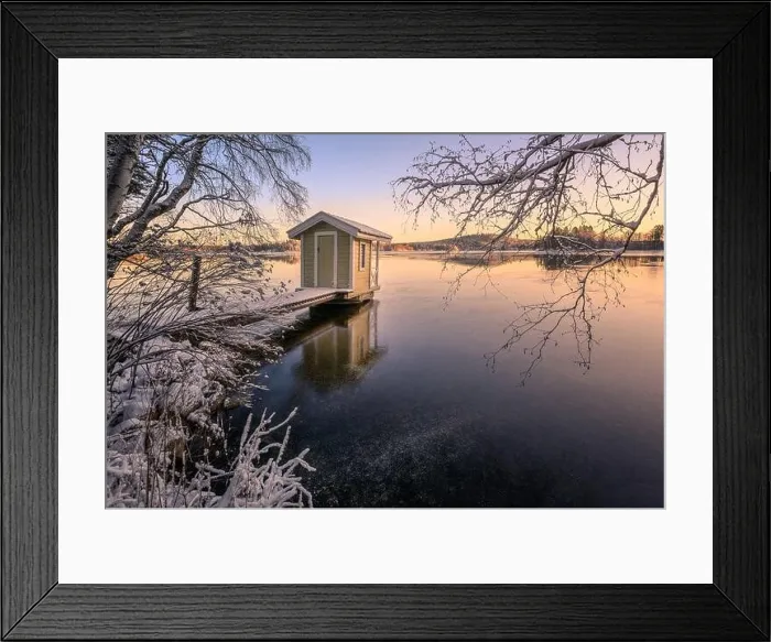 Framed Print : Scenic winter landscape with sunset and cozy cottage at icy and peaceful lake in Finland
