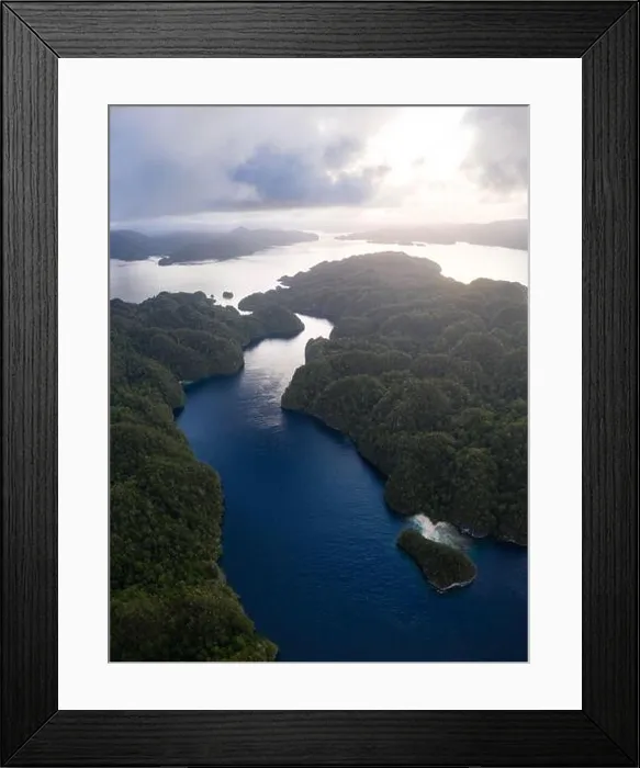 Framed Print : A narrow, coral-filled channel runs through islands in Raja Ampat, Indonesia. This tropical area is known for its incredibly high marine biodiversity Framed Print : A narrow, coral-filled channel runs through islands in Raja Ampat, Indonesia. This tropical area is known for its incredibly high marine biodiversity