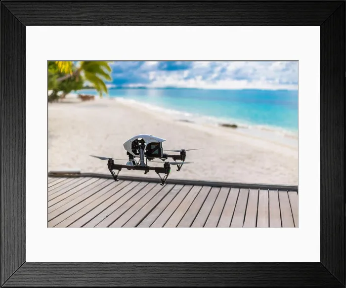Framed Print : Flying drone with mounted camera at the beach. Palm trees and blue lagoon Framed Print : Flying drone with mounted camera at the beach. Palm trees and blue lagoon