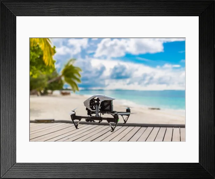 Framed Print : Flying drone with mounted camera at the beach. Palm trees and blue lagoon Framed Print : Flying drone with mounted camera at the beach. Palm trees and blue lagoon