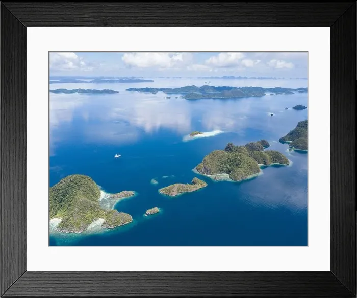 Framed Print : Beautiful limestone islands rise from the Raja Ampat, Indonesia, seascape. These islands are ancient, uplifted reefs now surrounded by fringing reefs Framed Print : Beautiful limestone islands rise from the Raja Ampat, Indonesia, seascape. These islands are ancient, uplifted reefs now surrounded by fringing reefs