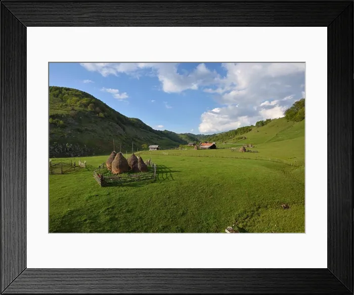Framed Print : Rural mountain landscape with haystacks against cloudy sky Framed Print : Rural mountain landscape with haystacks against cloudy sky