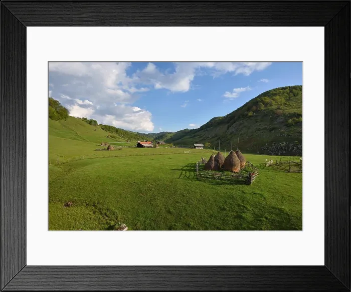 Framed Print : Rural mountain landscape with haystacks against cloudy sky Framed Print : Rural mountain landscape with haystacks against cloudy sky