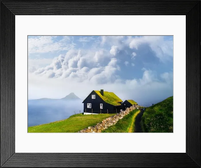 Framed Print : Foggy morning view of a house with typical turf-top grass roof and blue cloudy sky in the Velbastadur village on Streymoy island, Faroe islands Framed Print : Foggy morning view of a house with typical turf-top grass roof and blue cloudy sky in the Velbastadur village on Streymoy island, Faroe islands
