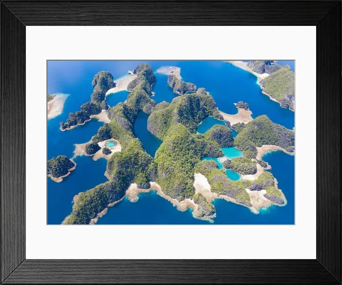 Framed Print : Rock islands, composed of limestone, rise from the tropical seascape in Raja Ampat, Indonesia. These islands are ancient, uplifted coral reefs Framed Print : Rock islands, composed of limestone, rise from the tropical seascape in Raja Ampat, Indonesia. These islands are ancient, uplifted coral reefs