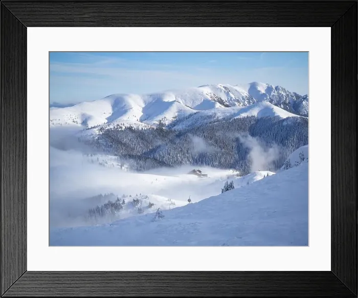 Framed Print : Mountain chalet in winter landscape with low altitude clouds in bright sunny day. Snow covered mountains Framed Print : Mountain chalet in winter landscape with low altitude clouds in bright sunny day. Snow covered mountains