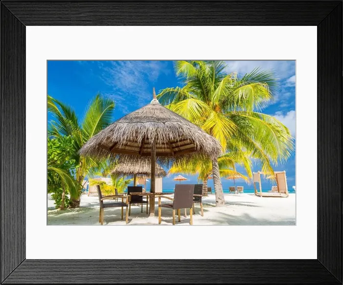Framed Print : Cafe on the beach, ocean and sky as tropical landscape. Chairs with table under palm parasol. Exotic summer outdoor restaurant family vacation concept Framed Print : Cafe on the beach, ocean and sky as tropical landscape. Chairs with table under palm parasol. Exotic summer outdoor restaurant family vacation concept