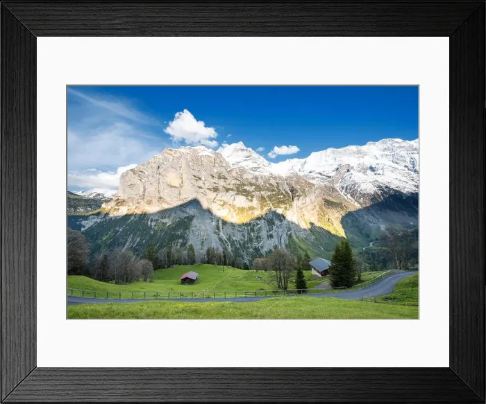Framed Print : Green fields and famous stunning touristic town with high cliffs in background, Lauterbrunnen, Bernese, Oberland, Switzerland Framed Print : Green fields and famous stunning touristic town with high cliffs in background, Lauterbrunnen, Bernese, Oberland, Switzerland