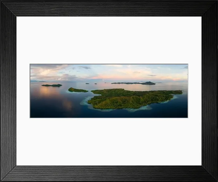 Framed Print : Sunrise illuminates clouds that drift over the calm waters of the Solomon Islands. This scenic region is known for its high marine biodiversity Framed Print : Sunrise illuminates clouds that drift over the calm waters of the Solomon Islands. This scenic region is known for its high marine biodiversity