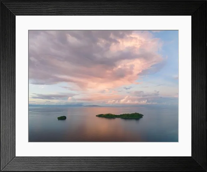 Framed Print : Sunrise illuminates clouds that drift over the calm waters of the Solomon Islands. This scenic region is known for its high marine biodiversity Framed Print : Sunrise illuminates clouds that drift over the calm waters of the Solomon Islands. This scenic region is known for its high marine biodiversity
