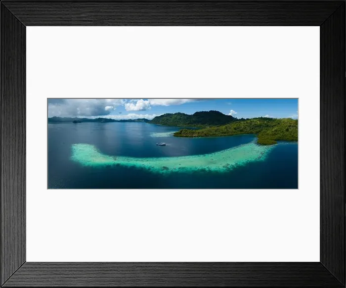 Framed Print : Extensive coral reefs fringe rainforest-covered islands in the Solomon Islands. This beautiful country is home to spectacular marine biodiversity