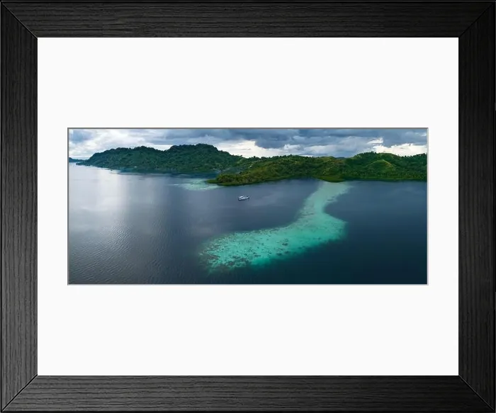 Framed Print : A scenic tropical island is fringed by a healthy coral reef in the Solomon Islands. This beautiful country is home to spectacular marine biodiversity
