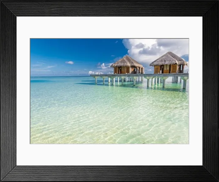 Framed Print : Tropical beach in Maldives with luxury over water bungalows or villas. Amazing sea lagoon with blue sky and clouds. Exotic travel destination Framed Print : Tropical beach in Maldives with luxury over water bungalows or villas. Amazing sea lagoon with blue sky and clouds. Exotic travel destination