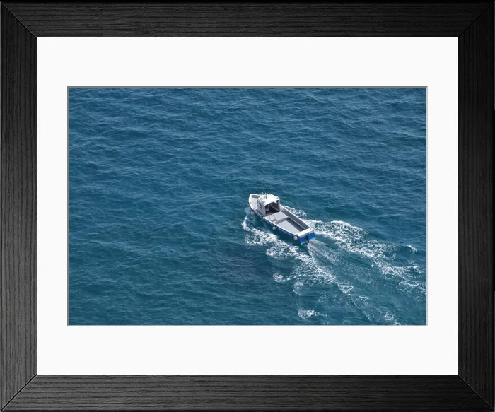 Framed Print : Aerial view of a white fishing boat on a blue clear sea water