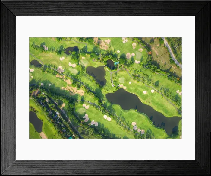 Framed Print : Aerial panoramic view drone shot of beautiful golf course with people playing golf in field Framed Print : Aerial panoramic view drone shot of beautiful golf course with people playing golf in field