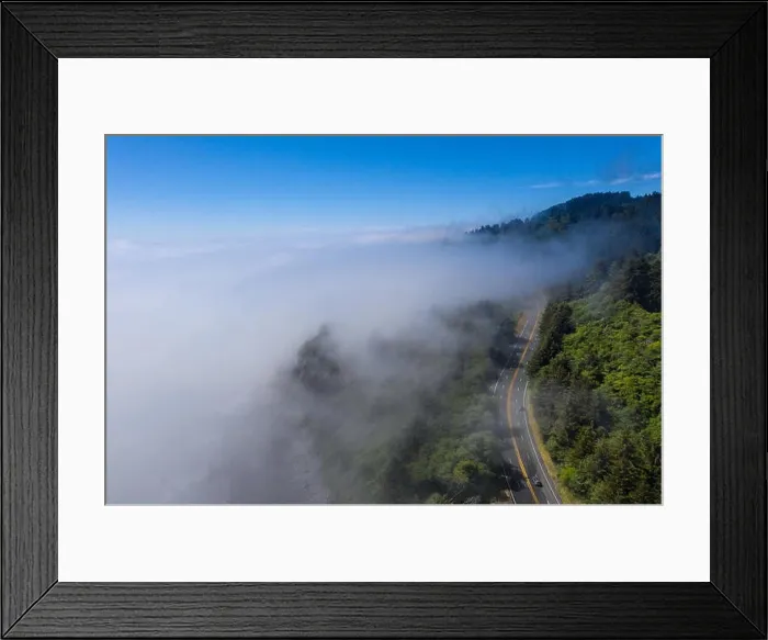 Framed Print : Seen from a bird's eye view, the foggy marine layer seeps over the Pacific Coast Highway that runs along the scenic coastline in Northern California Framed Print : Seen from a bird's eye view, the foggy marine layer seeps over the Pacific Coast Highway that runs along the scenic coastline in Northern California
