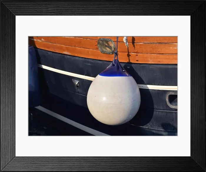 Framed Print : A Fender (boating) hanging on the board to protect the side of the sailing vessel from the damage. Italy Framed Print : A Fender (boating) hanging on the board to protect the side of the sailing vessel from the damage. Italy