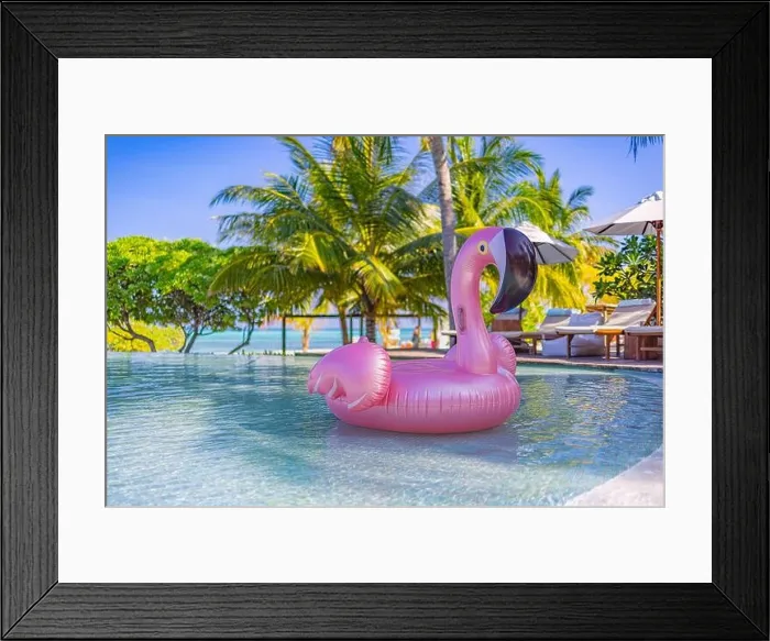 Framed Print : Luxury resort swimming pool with floating swan with blue sky and palm trees. Chairs, beds under umbrella, summer fun happy mood. Hotel pool, relax