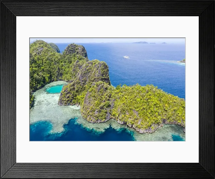 Framed Print : Seen from a bird's eye view, limestone islands rise from Raja Ampat's calm seascape. This tropical area is known for its amazing marine biodiversity Framed Print : Seen from a bird's eye view, limestone islands rise from Raja Ampat's calm seascape. This tropical area is known for its amazing marine biodiversity