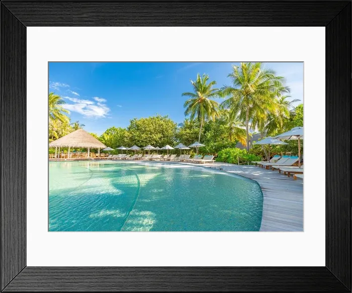 Framed Print : Summer outdoor tourism landscape. Luxurious beach resort with swimming pool and beach chairs or loungers under umbrellas with palm trees and blue sky Framed Print : Summer outdoor tourism landscape. Luxurious beach resort with swimming pool and beach chairs or loungers under umbrellas with palm trees and blue sky